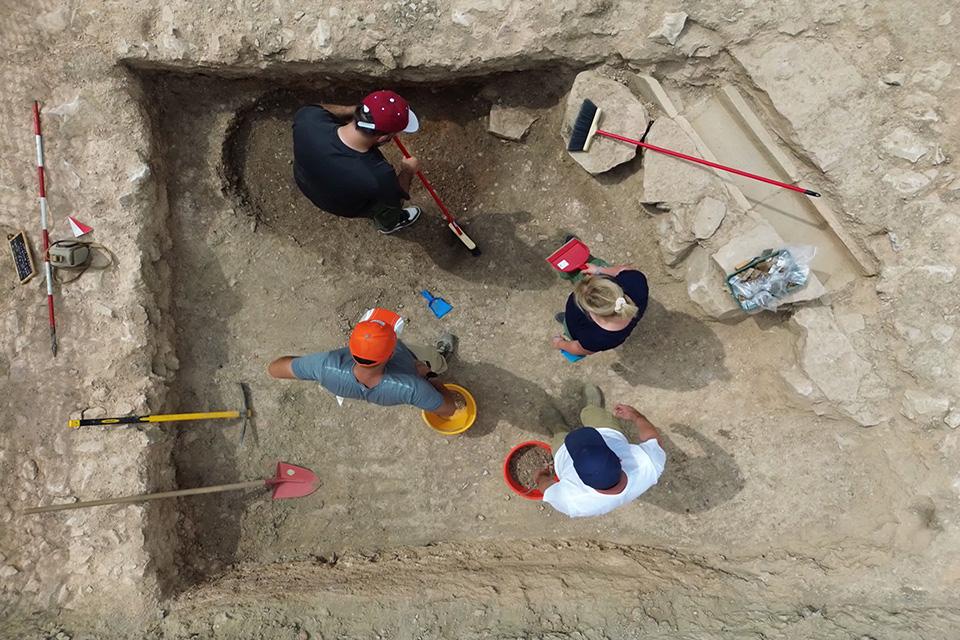 Excavators are seen from above working at the site, with brooms, shovels and buckets.