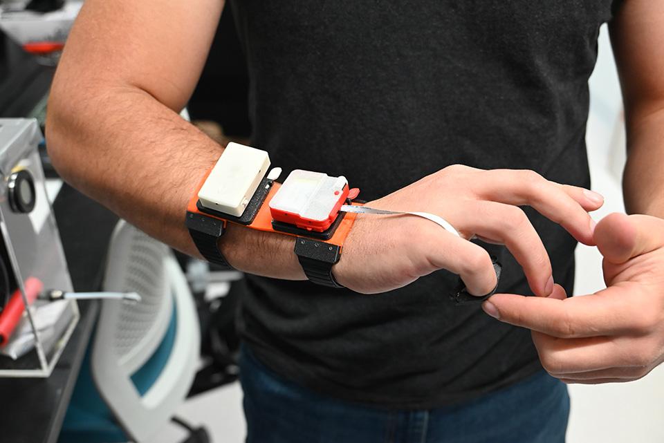 Nicolas Prudencio demonstrates a new device in the CHROME Lab.