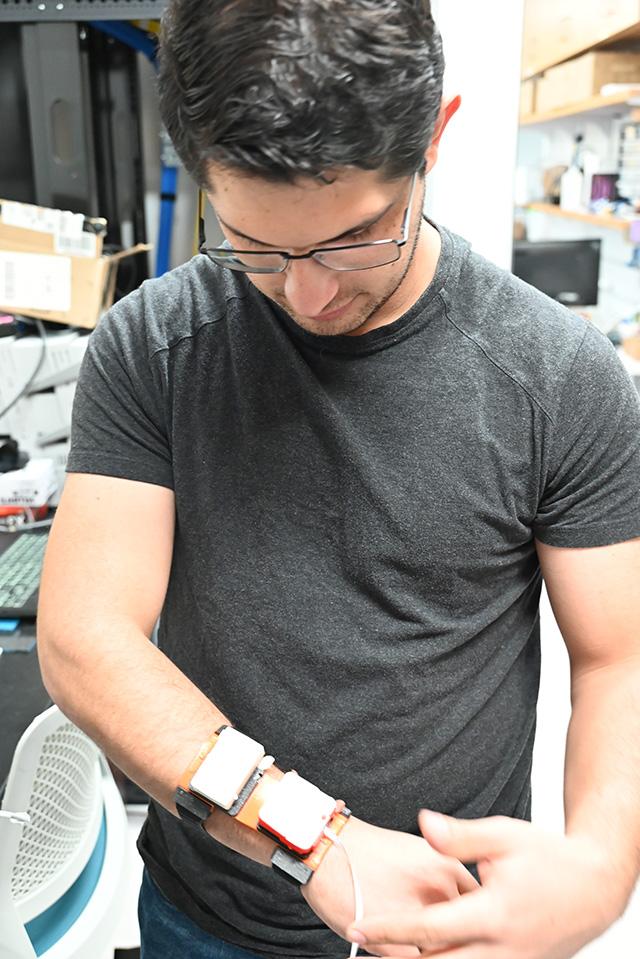 Nicolas Prudencio adjusts the wearable haptic device.