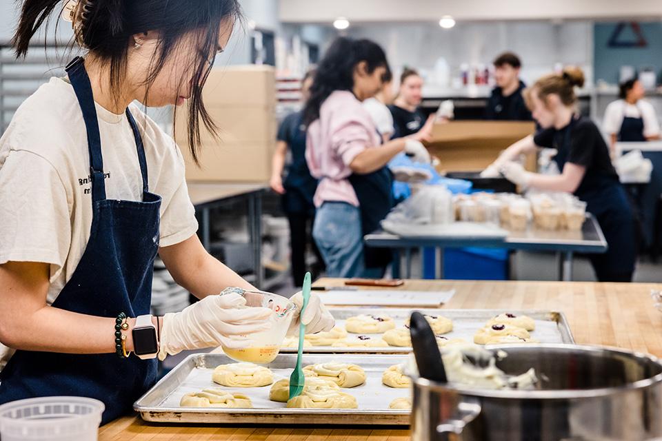 A student with Fresh Gatherings prepares a meal.